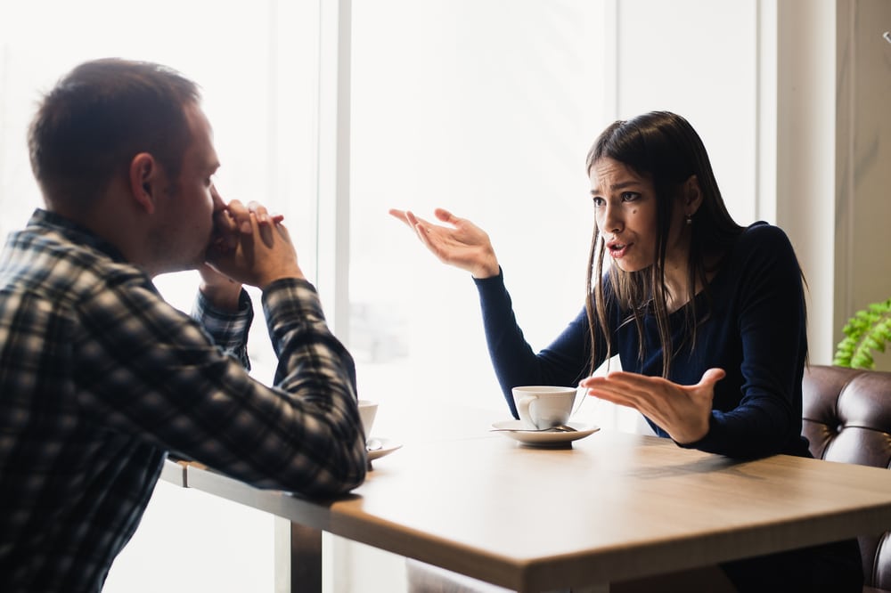 Young couple arguing in a cafe - What To Do When Your Leo Man Gets Mad At You