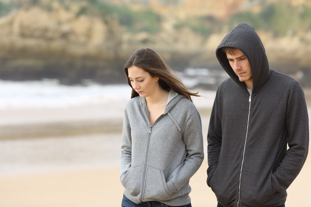 Couple of angry and sad teenagers together walking on the beach - The Leo Man with Taurus Rising